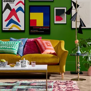 living room with green coloured wall and pillows on yellow sofa