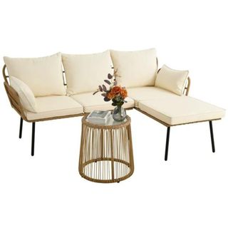 A cream L-shaped sofa with cushions and a rope round table