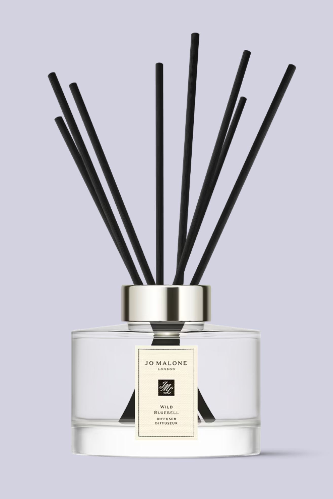 A glass reed diffuser with black reeds