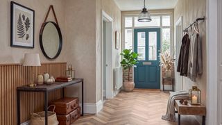 entrance hall with turquoise front door and herringbone wooden flooring