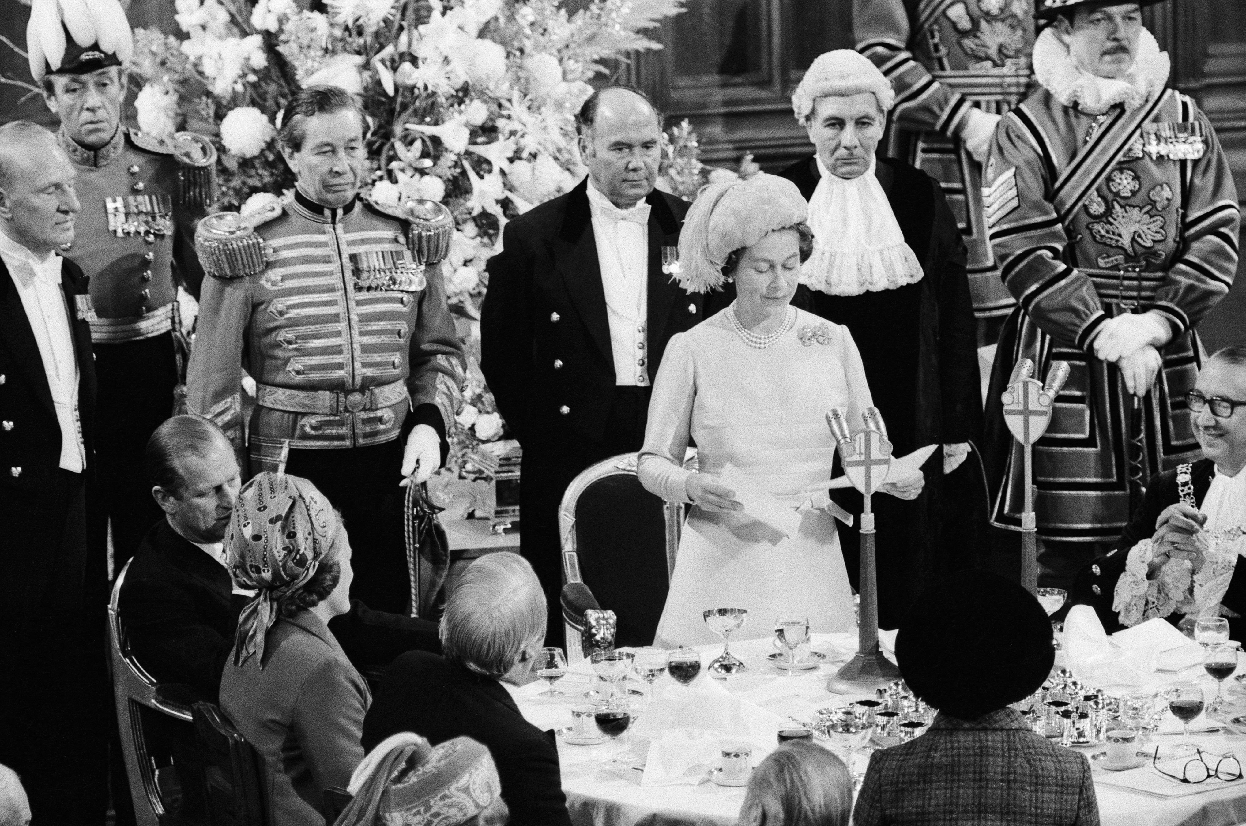 Queen Elizabeth giving a speech at a table of people on her 25th wedding annivesary