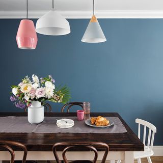 blue dining room with table and hanging lights