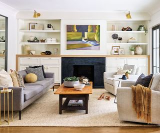 living room with gray sofa and alcove shelving with white walls
