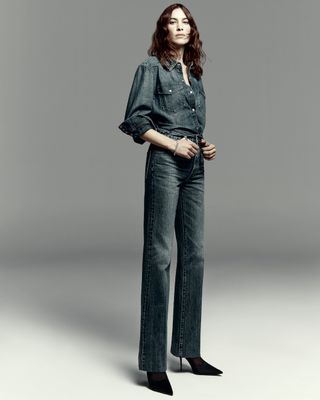 Alexa Chung wears Madewell pieces including a denim top and jeans in front of a plain backdrop