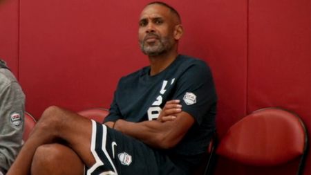 Grant Hill sitting in a gym with arms and legs crossed