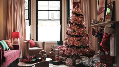 A living room with a pink Christmas tree in the corner and sico balls falling out of the fireplace