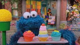 Cookie Monster looking at cupcakes in Cookie Monster's Bake Sale