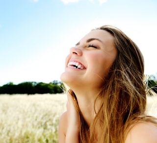 a woman smiling outdoors.