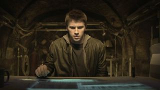 Garrett Hedlund sits in front of a futuristic looking computer in Tron: Legacy.