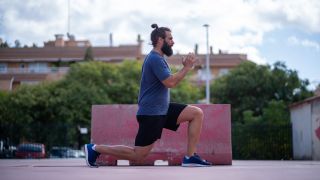 Man performs lunge exercise outside