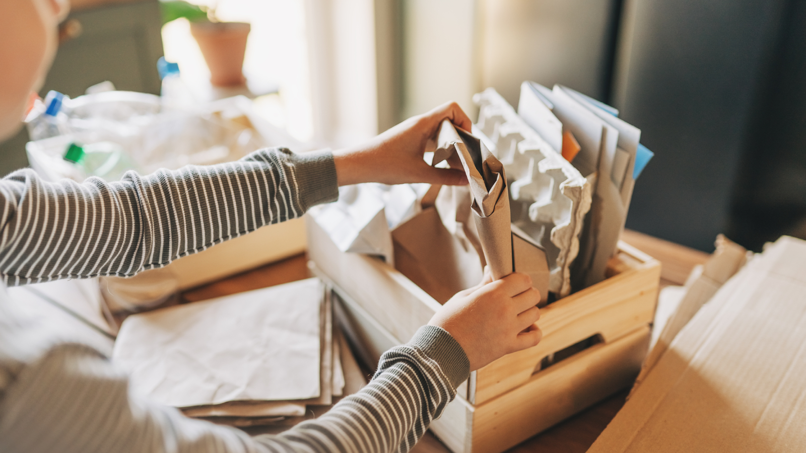 cardboard and paper being sorted into wooden box