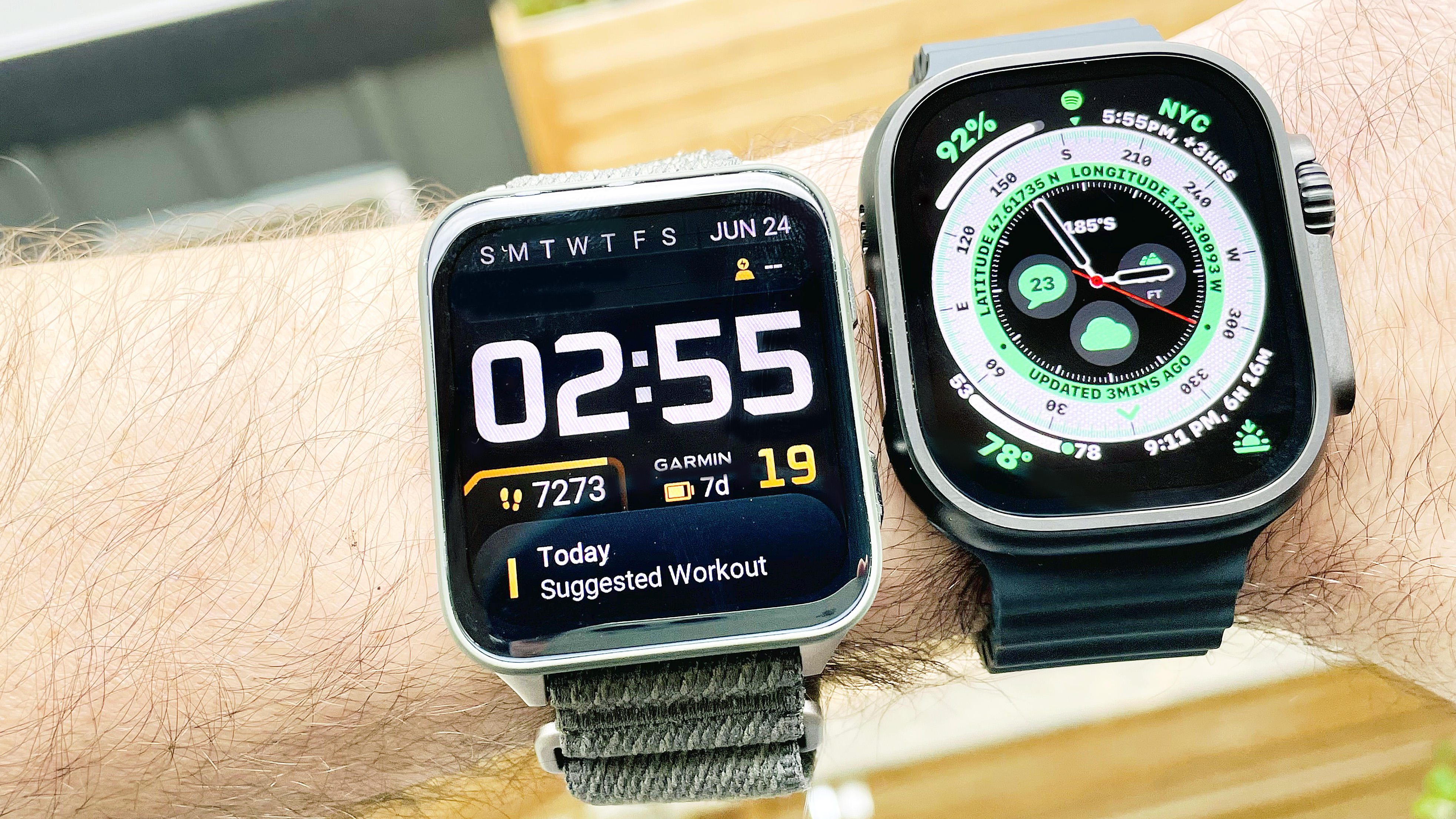 Close up of the Garmin Venu X1 smartwatch next to the Apple Watch Ultra 2