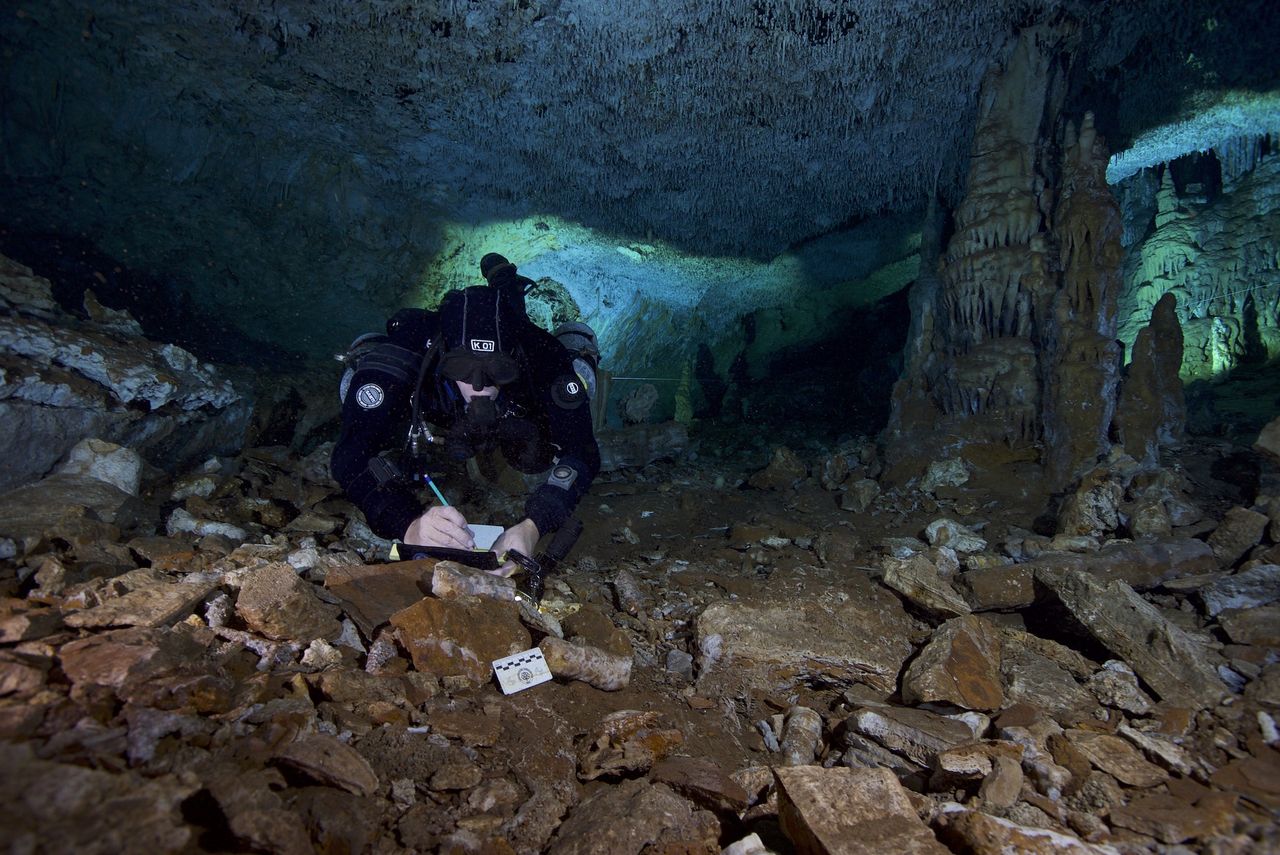 A diver looks for charcoal samples in the cave.