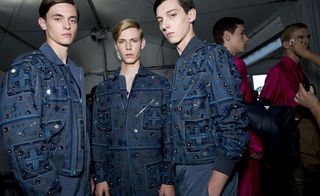 A row of three models modelling in a smallish room