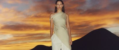 Model wearing Mango dress in front of a sunset