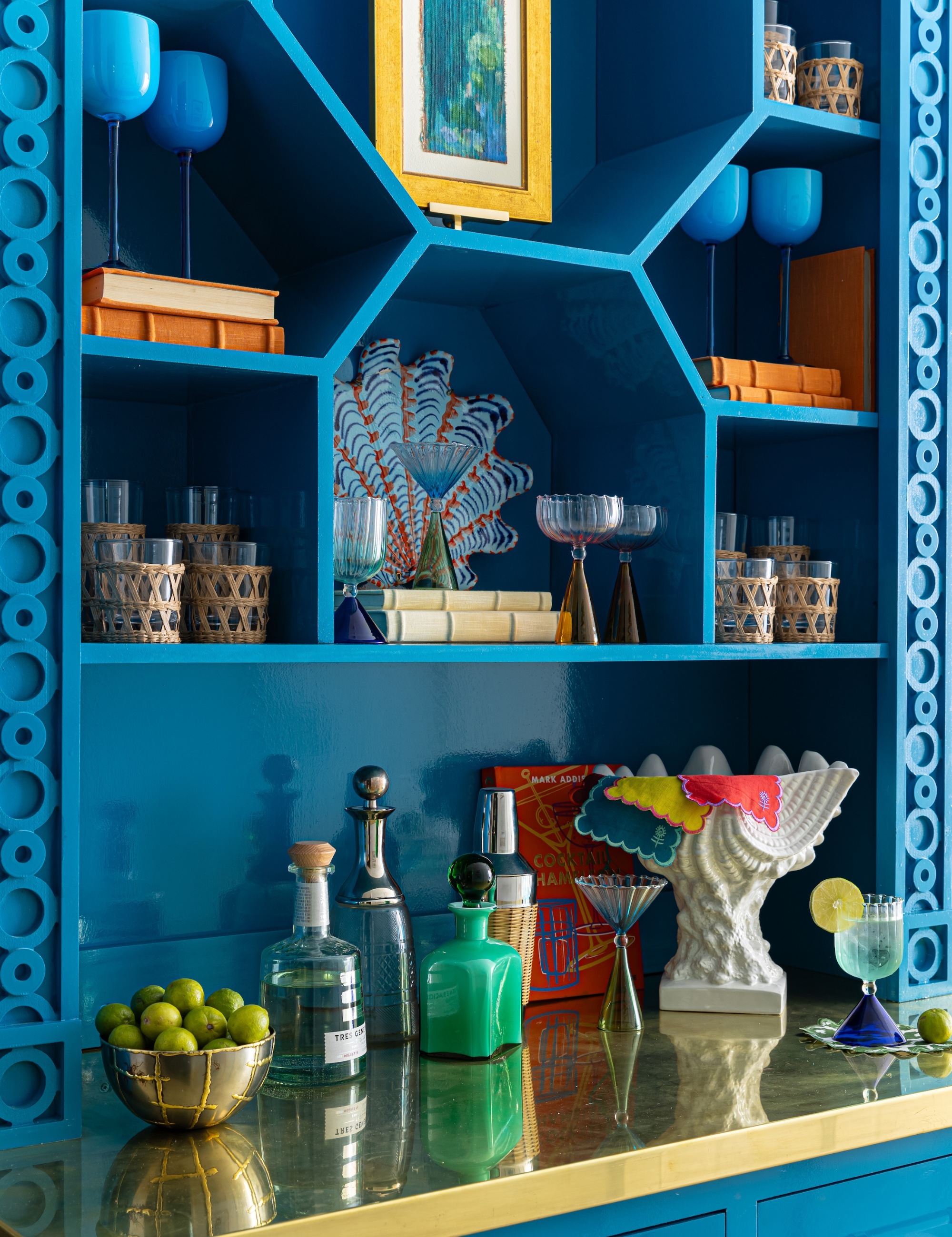 Teal bar setup with geometric shelves and colorful barware