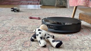 Roborock Saros 10R robot vacuum and mop with dog toys strewn around