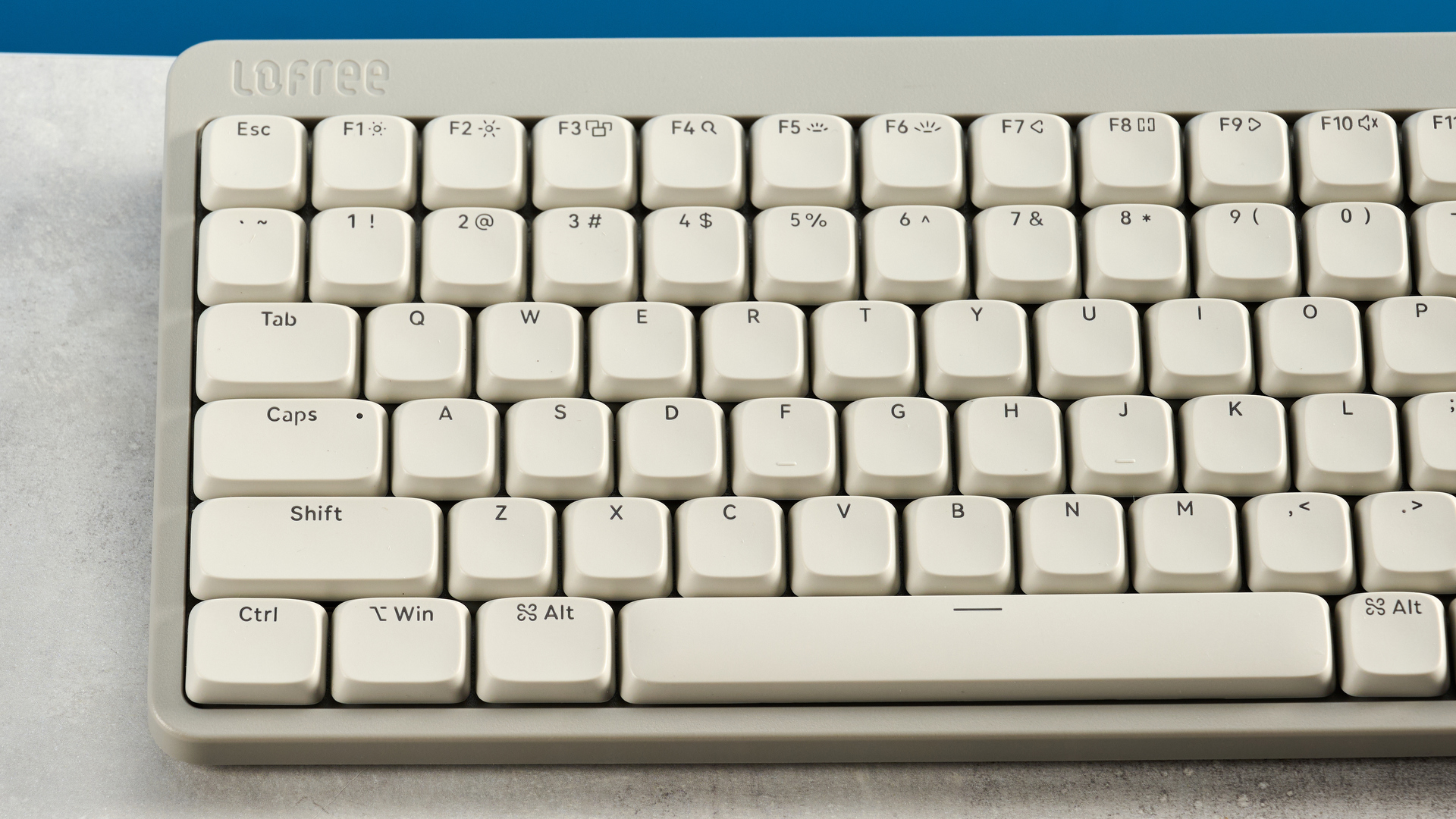 The Lofree Flow Lite84 on a stone surface against a blue background