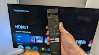 Philips OLED809 OLED TV with remote control in hand