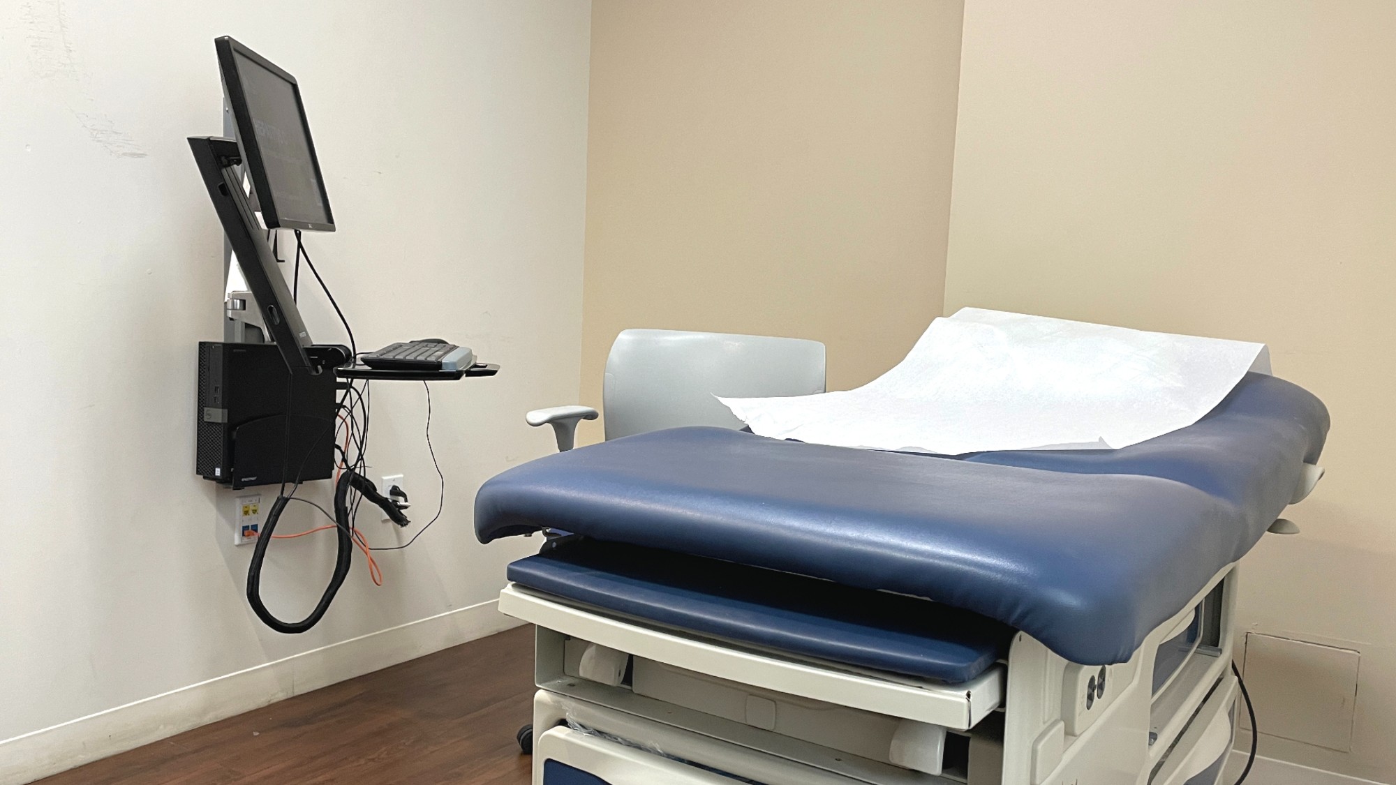 An empty doctor&rsquo;s office with a computer on the wall. 