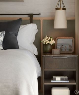 close up of a bed and nightstand with neutral decor and crisp white bed sheets