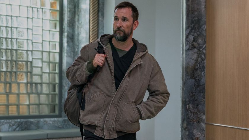Noah Wyle as Robby walking into The Pitt with a backpack slung on his left shoulder. 
