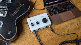 A Blackstar Polar 2 audio interface on a wooden floor with a laptop and electric guitar