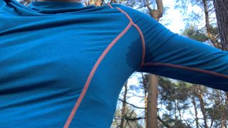 Close up showing sweat marks on runner's base layer top