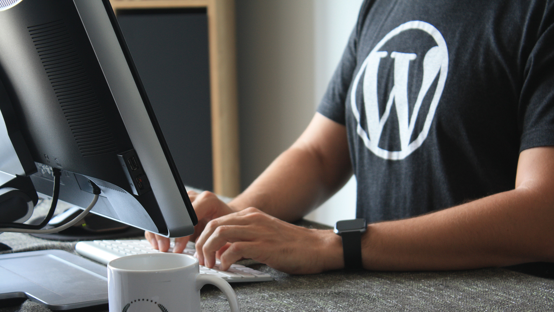 man working at computer in WordPress shirt