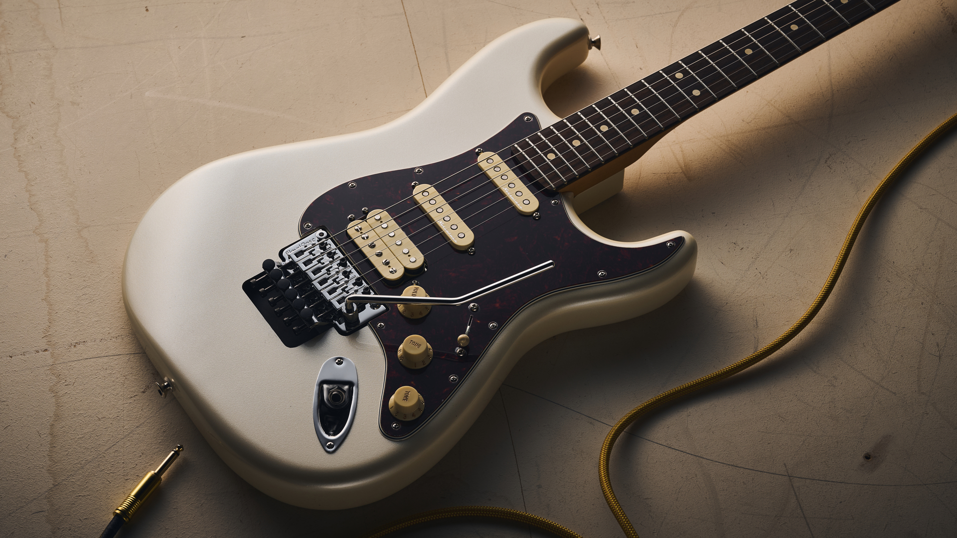 A Fender Player II Modified Stratocaster HSS Floyd Rose lying on a concrete floor