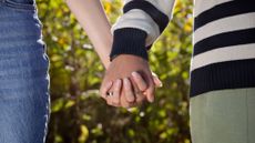 A stock image of a couple holding hands. 