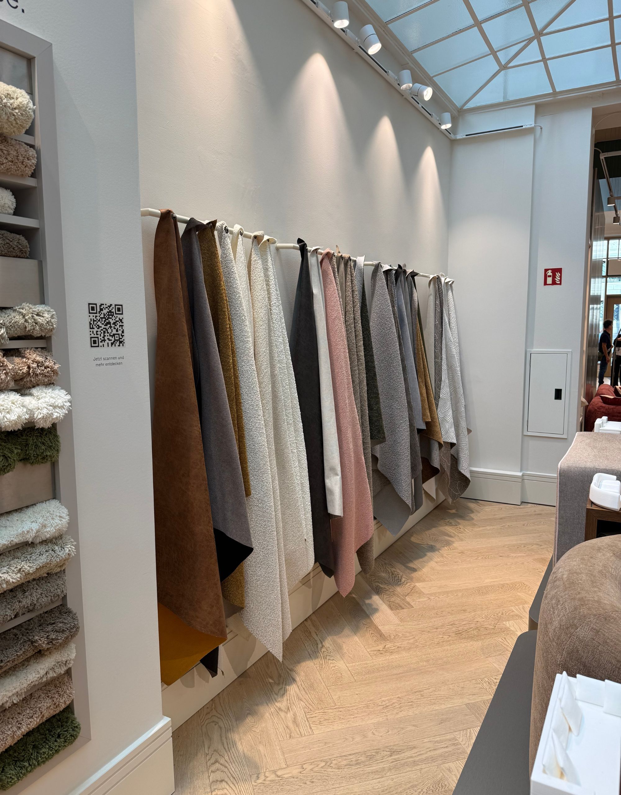 A scarf-like display of sofa fabrics lining the wall of Westwing's showroom in Munich