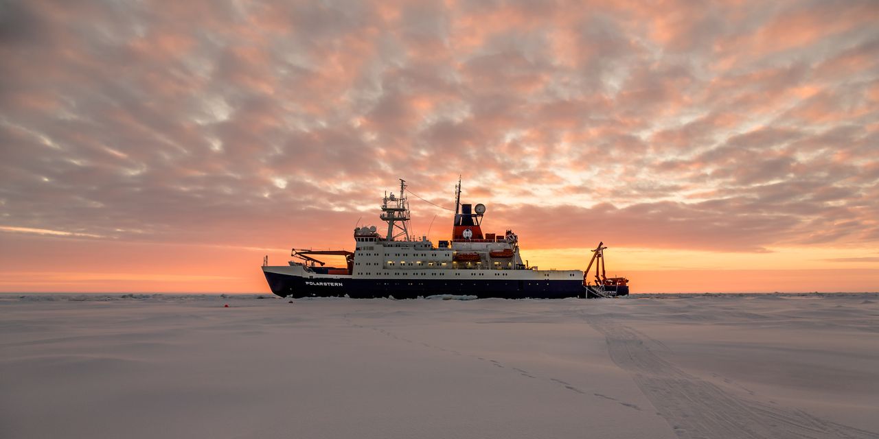 the ship rv polarstern in the morning light, surrounded by sea ice