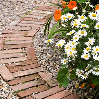 brick path with sea stones and flower