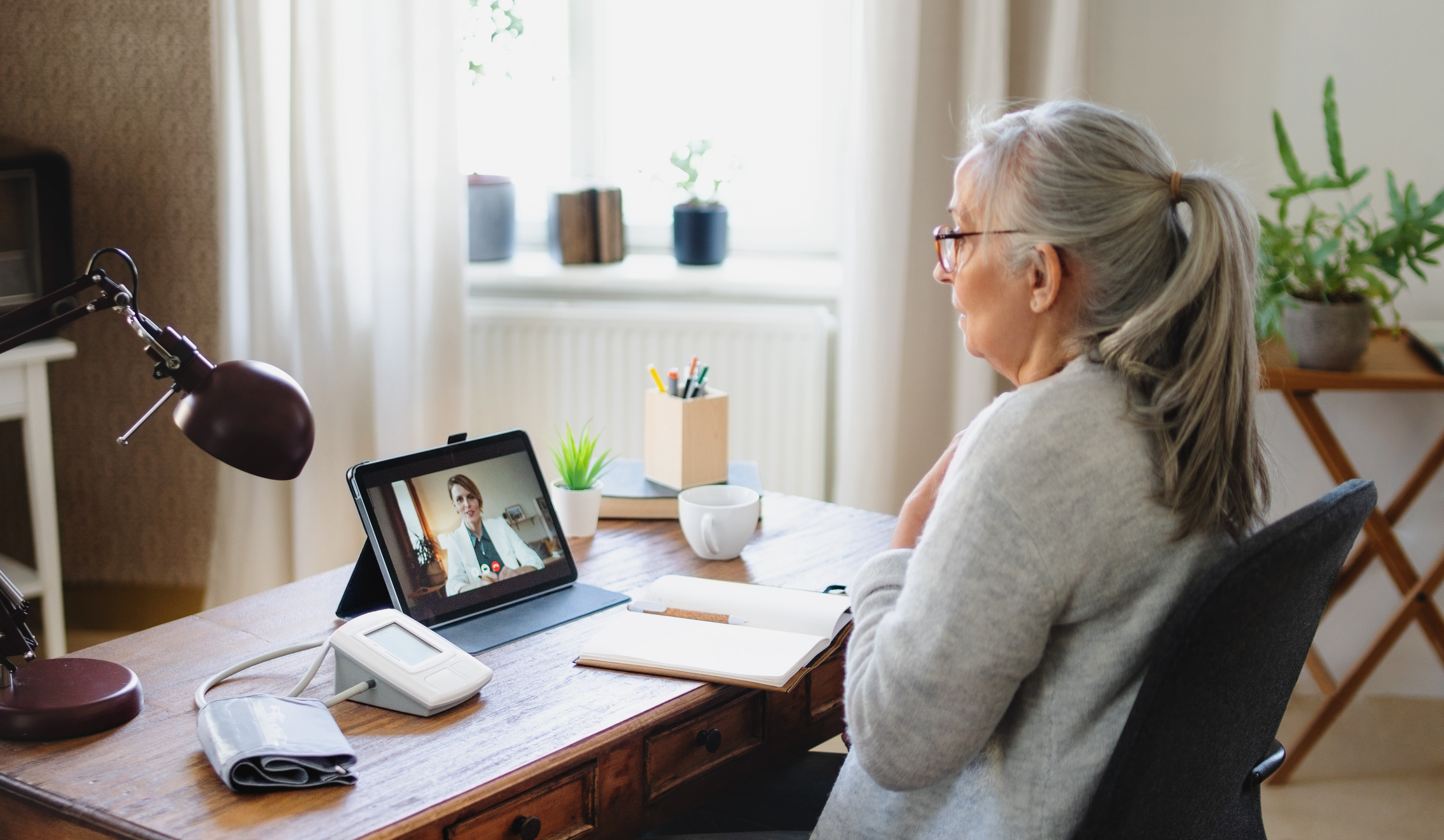 Depressed senior woman having video call with therapist, telemedicine and online therapy