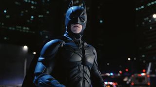 Batman (Christian Bale) looks over across Gotham City as police pursue him in The Dark Knight Rises.