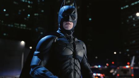 Batman (Christian Bale) looks over across Gotham City as police pursue him in The Dark Knight Rises.