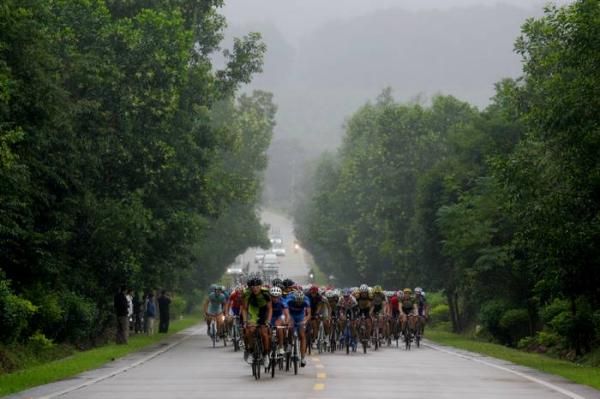 The peloton in pursuit up a small rise.
