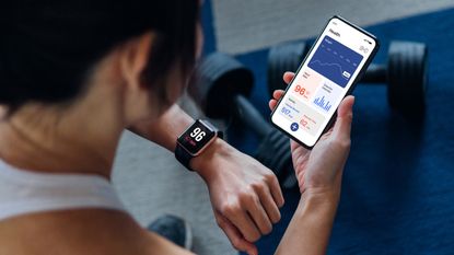 Woman looking at data on her fitness tracker and health app