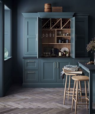 Dark and moody kitchen with Baltic Green pantry cupboard and dark painted walls