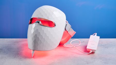 the ulike reglow led skincare mask showing its red LED light and control and charger