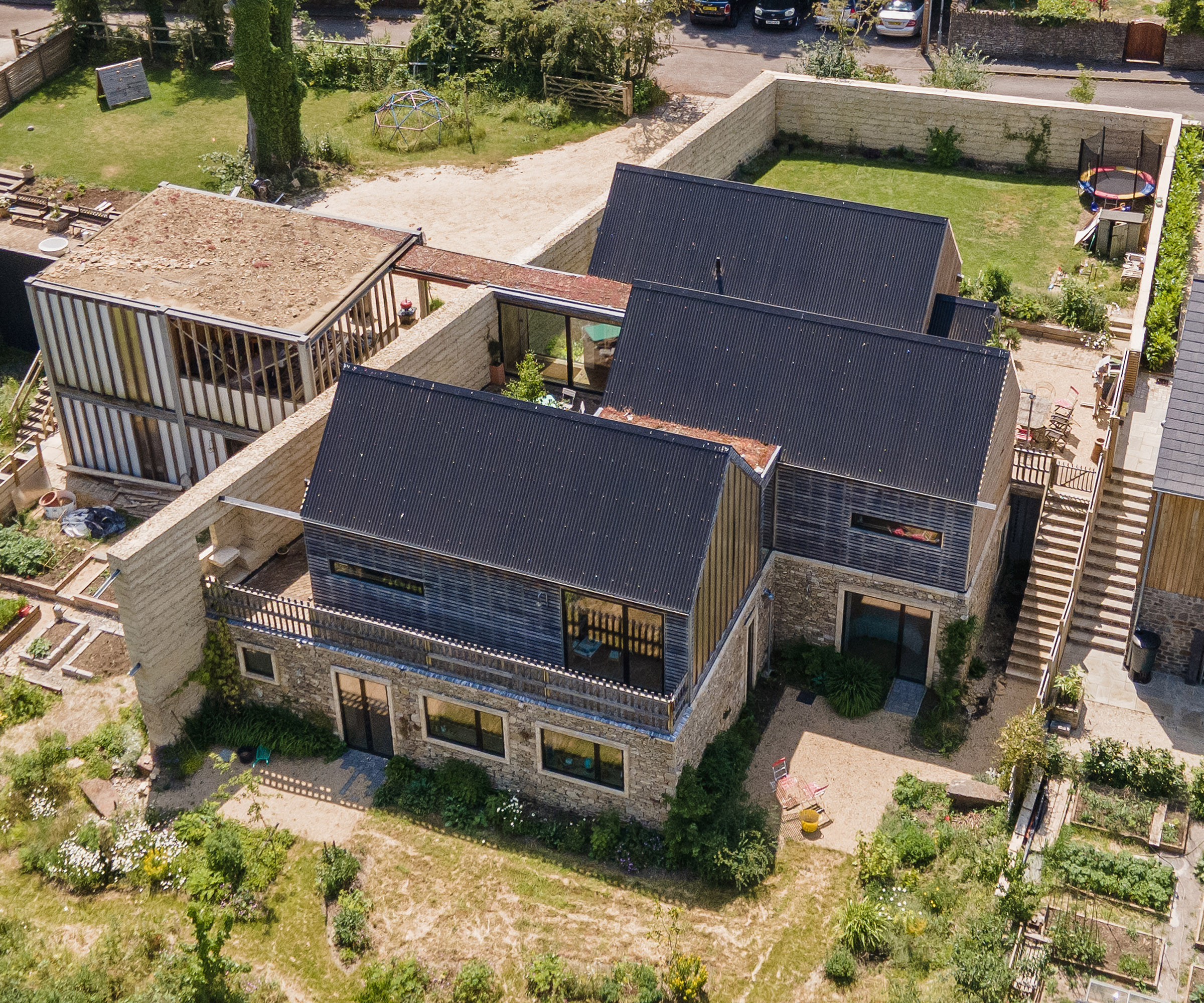 A drone shot of a large self-build home adjacent to a second self build plot.