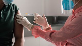 A medical worker administering a vaccine to a patient.