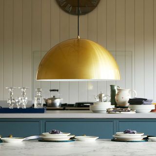 a large yellow gold dome light over a kitchen island