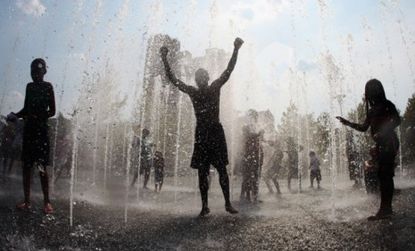 People cool off in a Baltimore fountain: The recent heat wave has inspired a new round of debate as to whether very high temperatures spur violent crime.