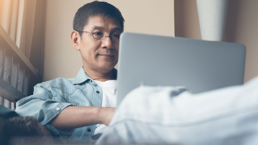 Man looking at laptop, working from home