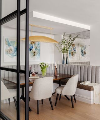 dining room with fitted banquette seats and with white walls with steel framed