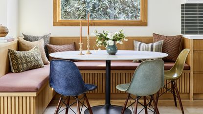 Samll dining room ideas with a white oak corner bench, round table and colored chairs