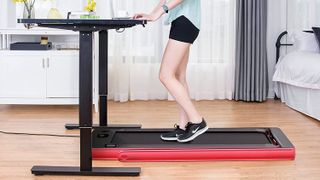 best under desk treadmills: Woman using treadmill while working at standing desk