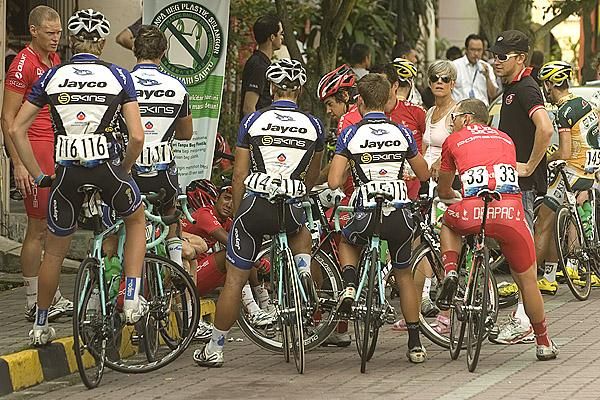 Australian teams Drapac Porsche (red) and Jayco Skins get together for a chat prior to the final stage start in Kuala Kubu Baru.